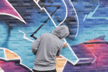 Joven grafitero pintando un mural