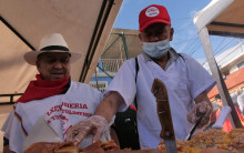 personas vendiendo lechona